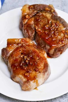 two pieces of meat sitting on top of a white plate