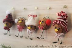 a group of small stuffed animals hanging on a wall next to a christmas tree branch