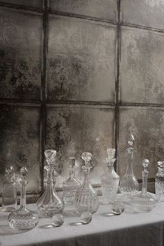 a table topped with lots of glass vases