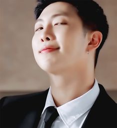 a man in a suit and tie looking up at the sky with his eyes closed