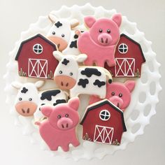 decorated cookies in the shape of farm animals are on a plate with a white background