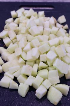 chopped potatoes on a cutting board ready to be cut into wedges or cubes