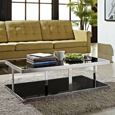 a living room with a couch, coffee table and rugs on the floor in front of it