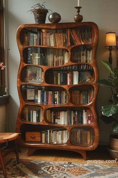 a book shelf with many books on it in a living room next to a window