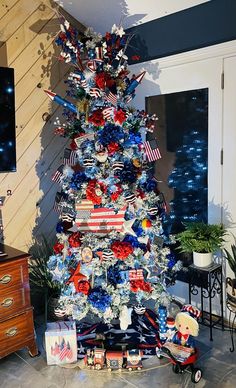 a decorated christmas tree with red, white and blue decorations in the shape of an american flag