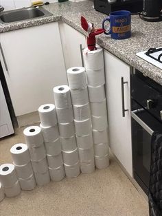 several rolls of toilet paper are stacked on top of each other in the corner of a kitchen