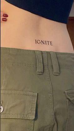 a woman's stomach with the word ignite written on her lower back side