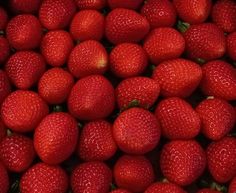 a pile of red strawberries sitting on top of each other