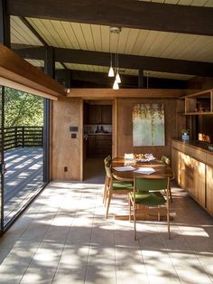 a dining room and kitchen area with sliding glass doors that open up to the outdoors