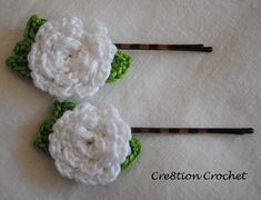 two crocheted hair pins with flowers on them