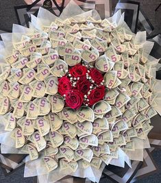 a bouquet of flowers made out of money with red roses in the center on top