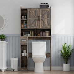 a white toilet sitting in a bathroom next to a wooden shelf