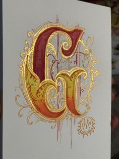 the letter c is painted in gold and red