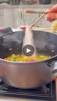 a person stirring food in a pot on the stove