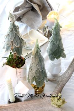 some plants and candles are on a table