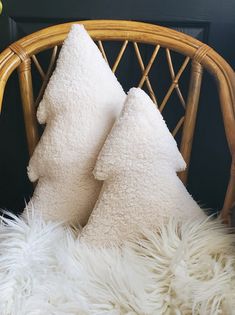 two white pillows sitting on top of a chair