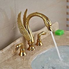 a golden faucet with water running from it's spout in a bathroom