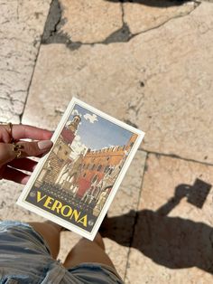 a person holding up a piece of paper with the word verona on it