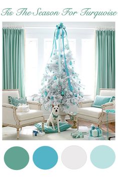 a living room decorated for christmas with a white tree and teal ribbon on it