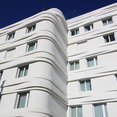 a tall white building with many windows on it