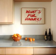 a bowl of oranges sitting on top of a kitchen counter