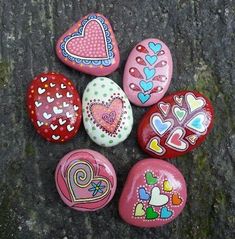 painted rocks with hearts on them sitting on the ground