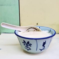 a blue and white bowl filled with yogurt sitting on top of a counter