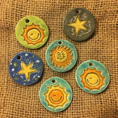 four ceramic sun and moon ornaments on a burlock