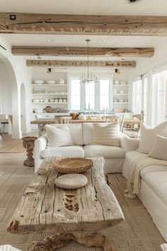 a living room filled with white furniture and lots of wood