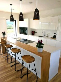 a kitchen with an island and stools in front of the counter top that has flowers on it