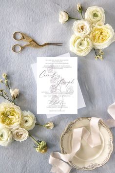 a table topped with flowers and paper next to a pair of scissor scissors