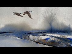 two birds are flying in the sky above some snow covered ground and water with trees behind them