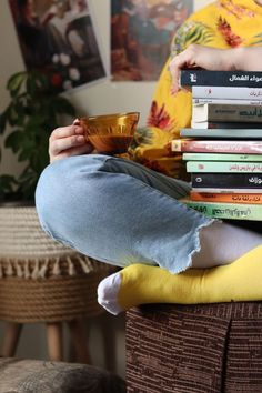 a person sitting on top of a pile of books with a bowl in front of them