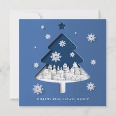 a blue christmas card with a paper cut tree and snowflakes on the bottom