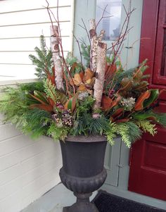 a planter filled with lots of greenery sitting on the side of a building