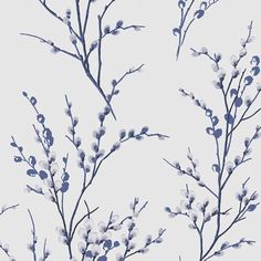 a branch with blue flowers on it against a light gray background that is slightly blurry