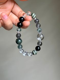 Size:  8-14mm Material:  Clear Quartz, Serpentine, Seraphinite, Black Rutilated Quartz, Green Phantom Quartz, Black Tourmaline, Silver Plated Copper Accessories Elevate your energy and style with my handcrafted gemstone bracelet! Only ONE availability - Order it now! You will receive the product as shown in the picture. This bracelet is suitable for wrist sizes ranging from 5.5-6 inches (14-15 cm) which is standard female size. If your wrist size falls outside this range, please inform me after purchasing, and I will adjust the beads accordingly to fit your size. Note: Sizes are actual wrist circumference, not the length of the bracelet. So, please MEASURE YOUR WRIST. Please Read: I strive to provide you with high-quality, affordable jewelry. Each piece is crafted with love and care. While Black Gemstone Bracelet, Clear Quartz Bracelet, Copper Accessories, Meditation Bracelet, Phantom Quartz, Crystal Healing Stones, Mineral Stone, Healing Bracelets, Quartz Bracelet