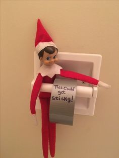 an elf is hanging on the wall with a roll of toilet paper in his hand