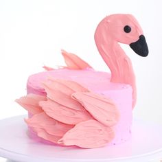 a cake decorated with pink frosting and a flamingo figure on top of it