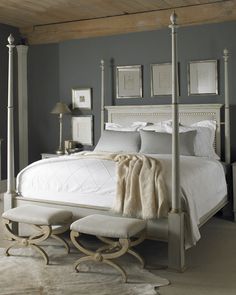 a white bed sitting under a wooden ceiling