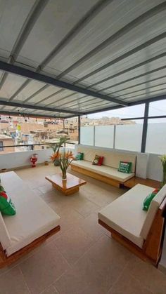 an outdoor living area with couches, tables and plants on the roof top deck