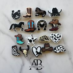 a collection of cowboy themed pins on a marble surface