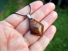 This necklace puts nature's beauty on full display! I specially selected and carved this grain in this gorgeous Exotic Bocote wood to bring out this stunning grain pattern.  A hand rub finish is applied and then the pendant is buffed to a buttery smooth final finish that feels amazing to the touch. You can choose from a variety of necklace/cording options including: 18" or 22" stainless steel chain A variety of colors of satin cording with sliding knots that allow you to adjust up to any desired Brown Carved Round Pendant Necklace, Natural Carved Necklaces As Gift, Wooden Pendant Necklace For Gift, Nature-inspired Wooden Pendant Jewelry, Carved Natural Wood Necklaces, Artisan Natural Wood Pendant Necklace, Natural Wood Pendant Jewelry For Gifts, Natural Wood Spiritual Necklaces For Gifts, Natural Wood Pendant Jewelry As Gift