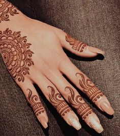 a woman's hand with henna tattoos on it