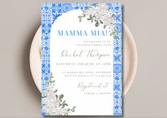 a blue and white wedding card with flowers on it