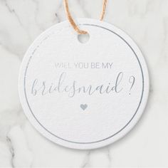 a bridesmaid ornament hanging on a marble background with the words will you be my bridesmaid?