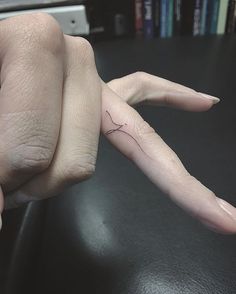 a woman's hand with a tiny tattoo on it