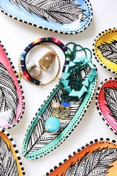 an assortment of colorful jewelry and bracelets laid out on a white surface with different designs