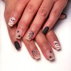 a woman's nails with spider webs on them and black tips are shown