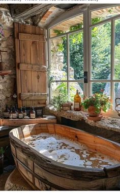 an old fashioned bathtub is in the middle of a room with large windows and potted plants